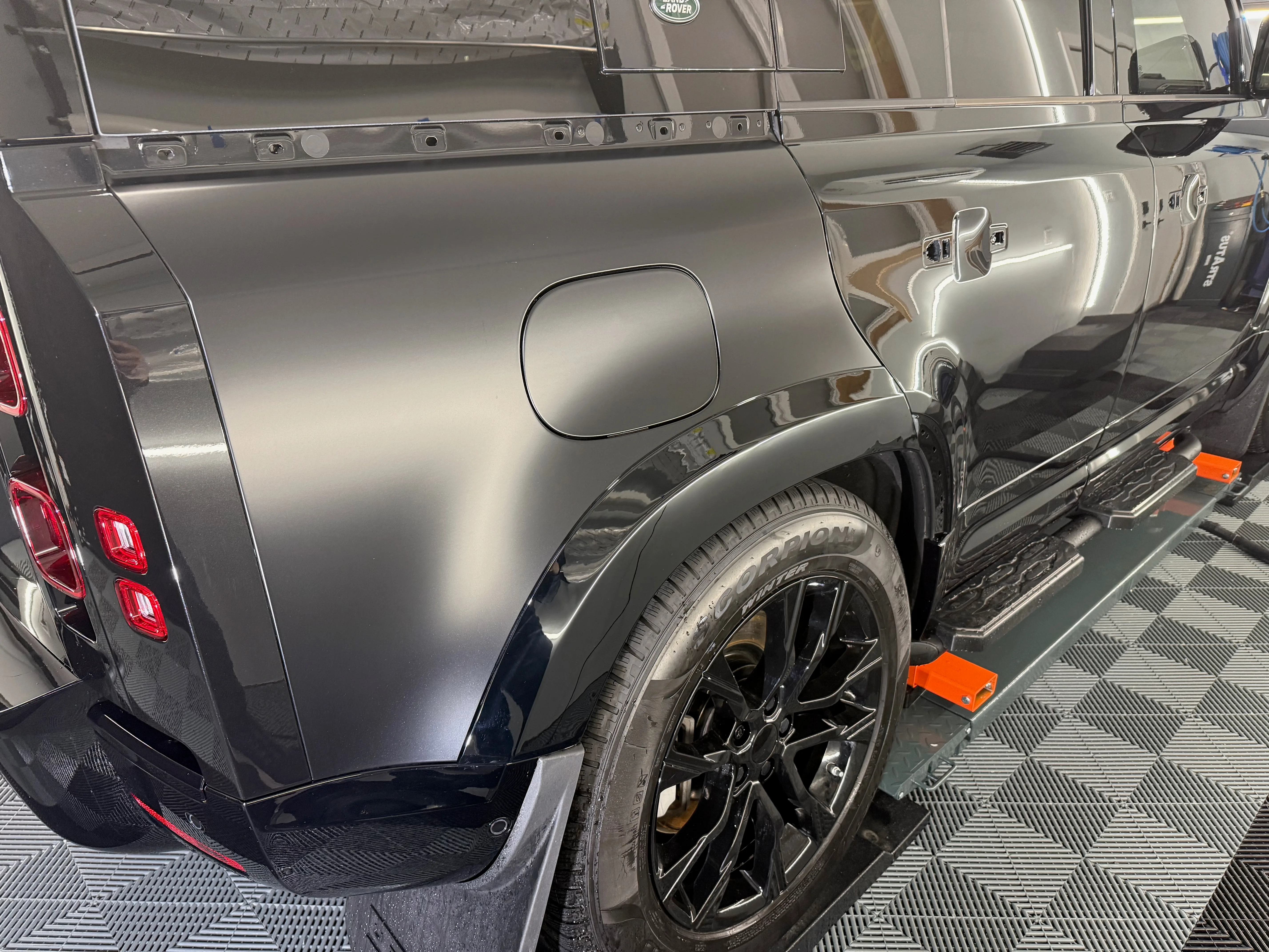 Finished rear quarter panel of a Land Rover Defender with flawless paint protection film installation — no visible edges, seams, or imperfections