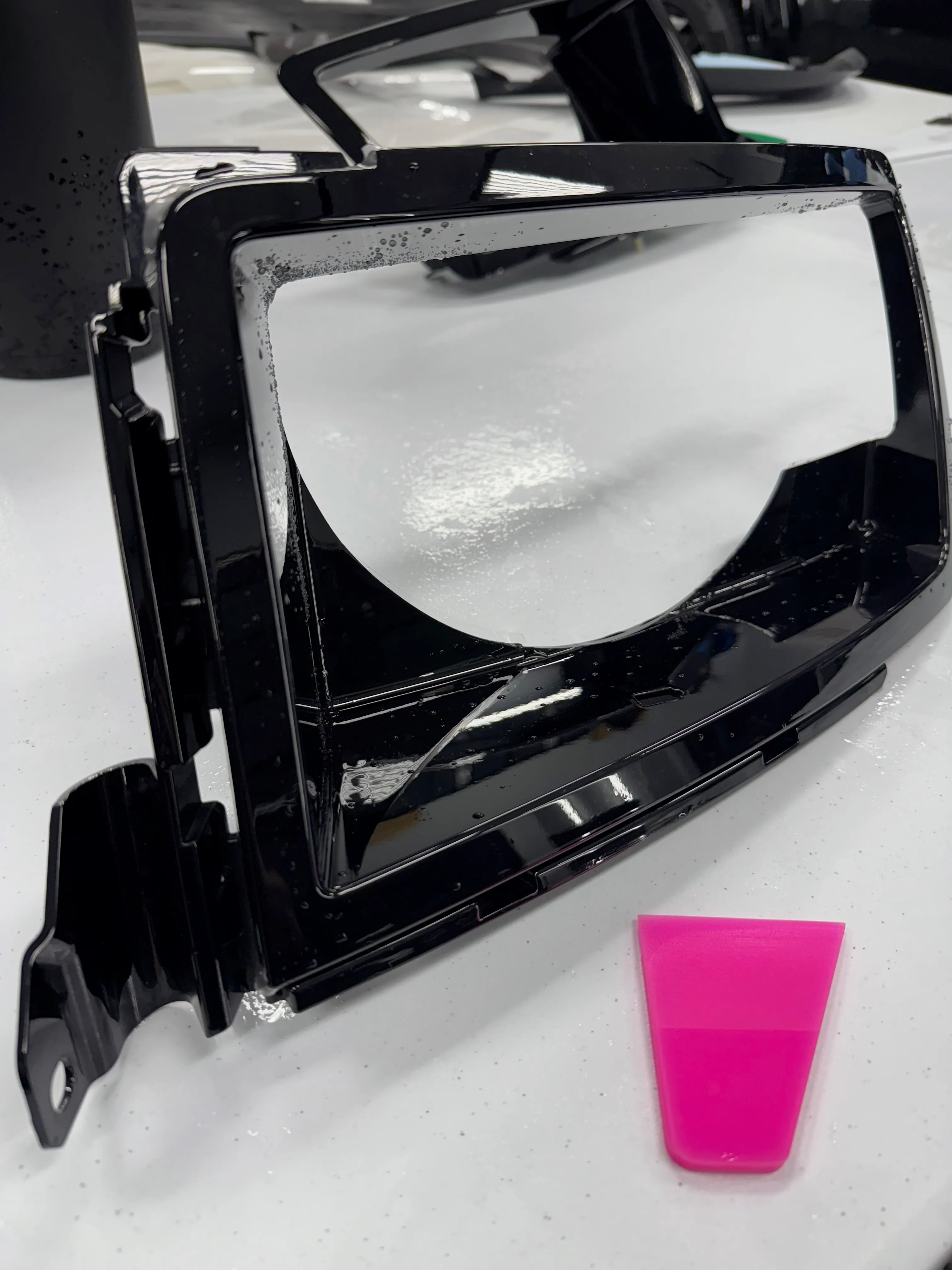 Headlight housing removed from vehicle and wrapped in paint protection film off-car for complete coverage at Garage Knights Ottawa