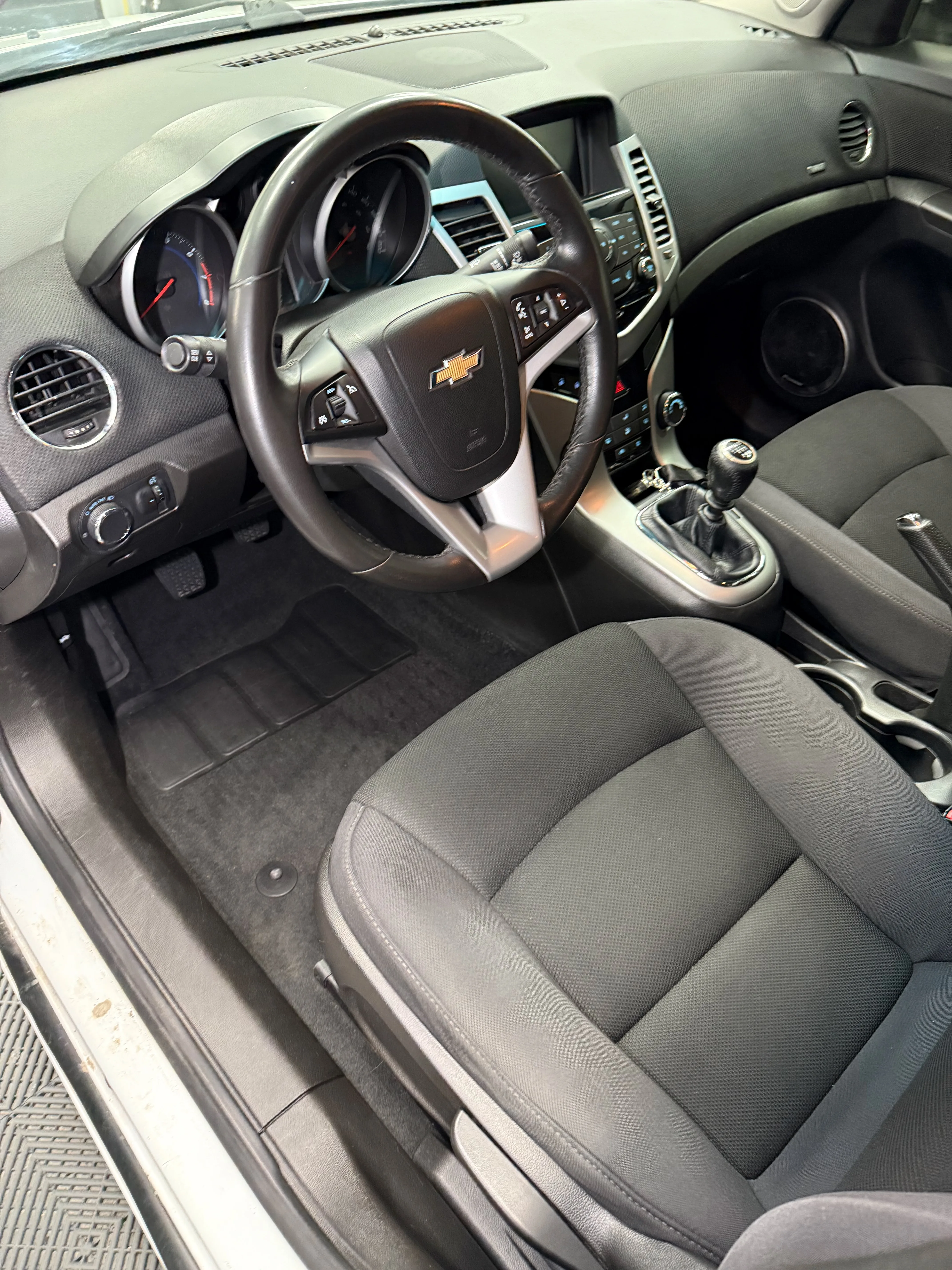 Interior detailing after — driver side with clean floor mats and restored dashboard