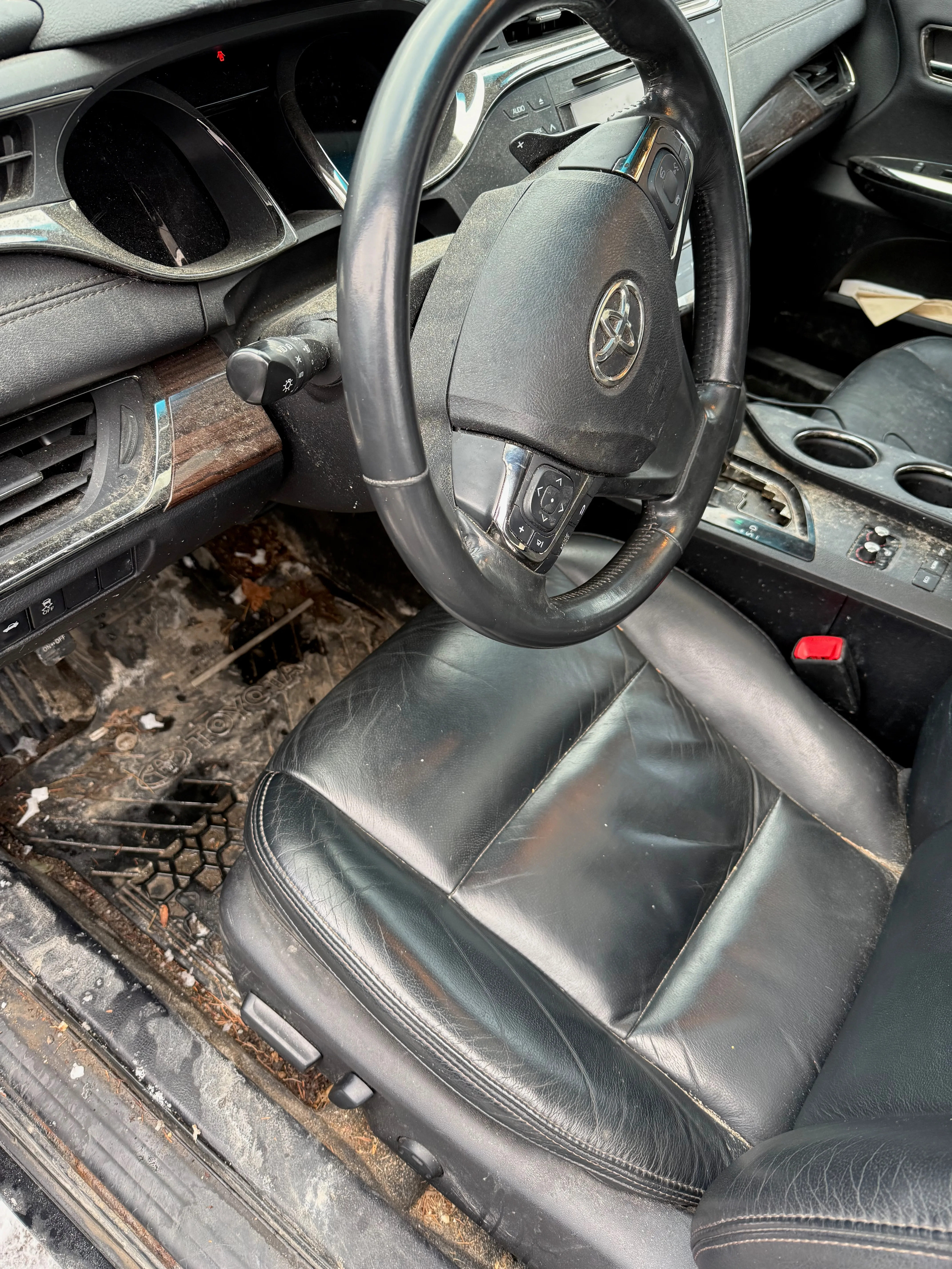 Interior detailing before — Toyota Avalon with muddy floors and soiled door sills