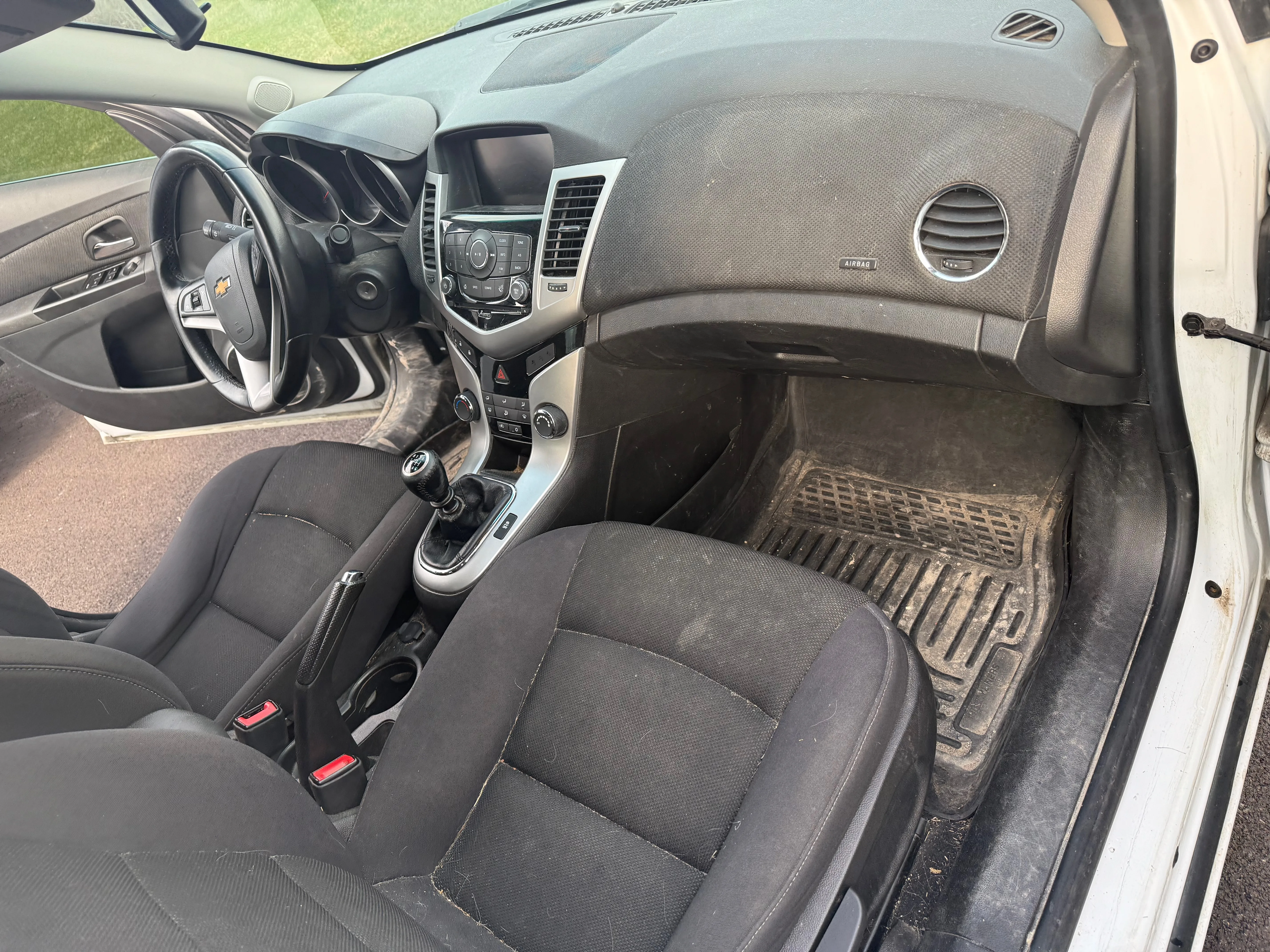 Interior detailing before — passenger side with dirty carpets and dusty trim