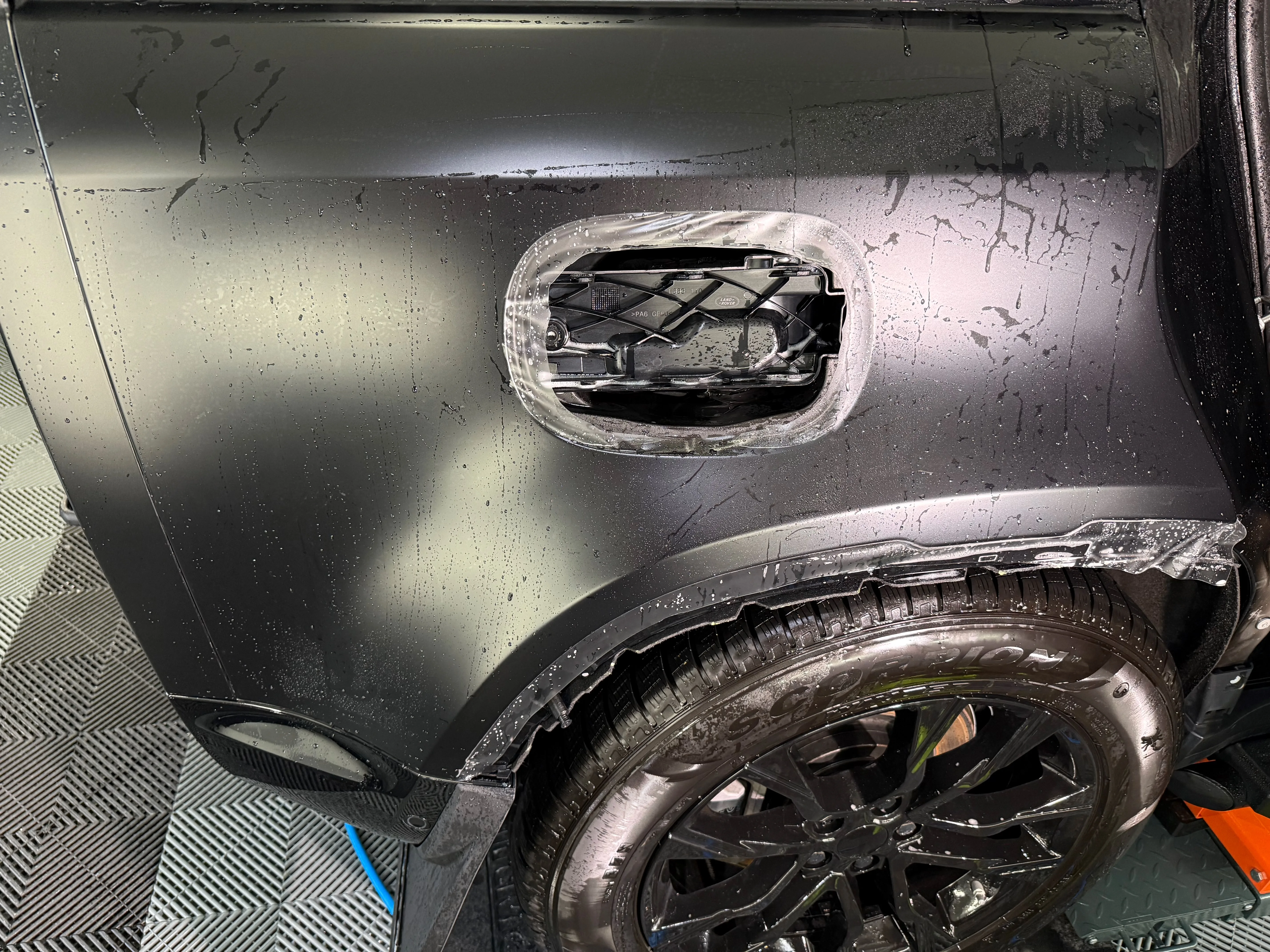 PPF being precision-trimmed around gas cap on Land Rover Defender rear quarter panel