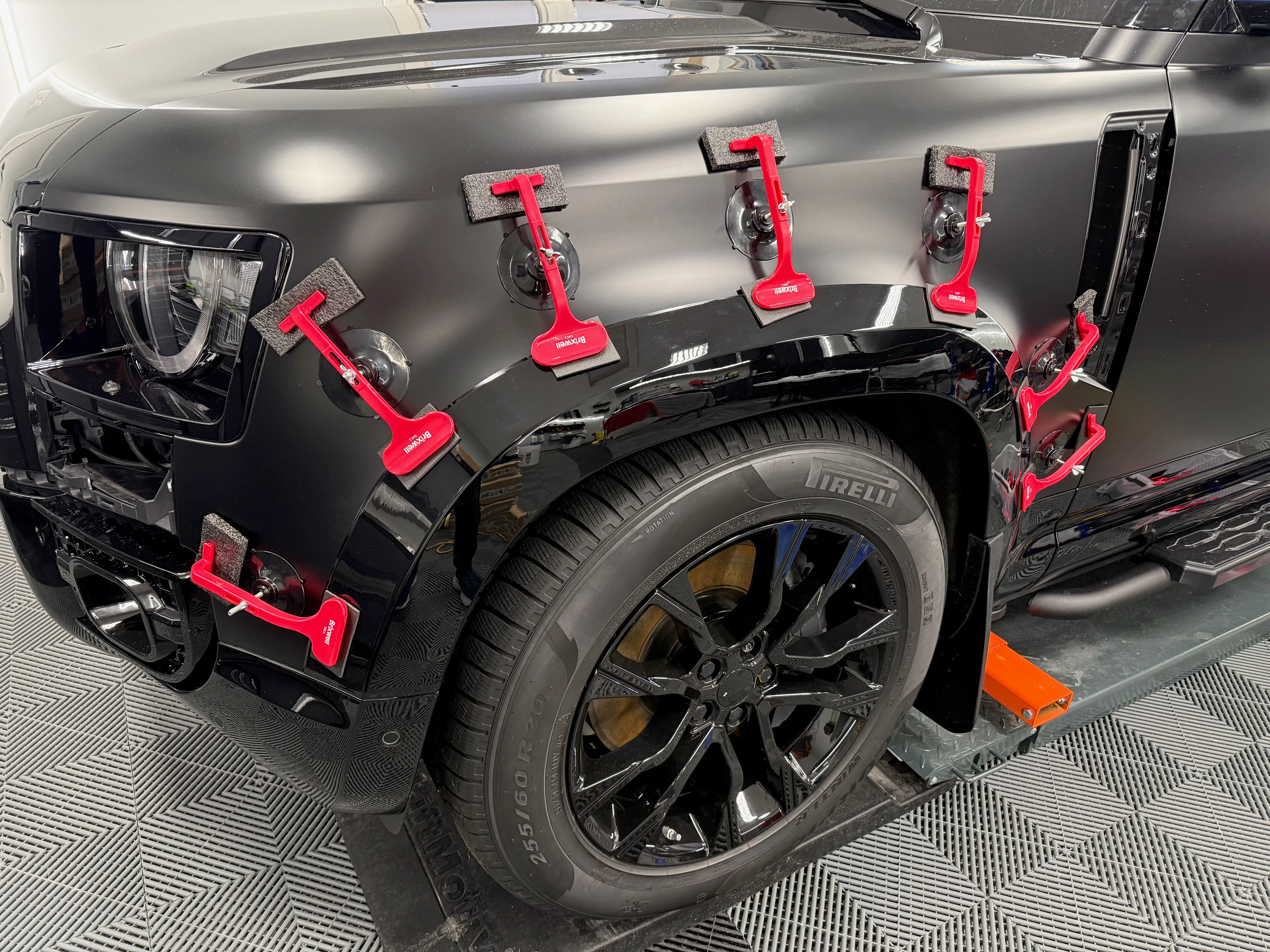 Urban Automotive wide arch extensions being fitted to Land Rover Defender front fender with precision clamps